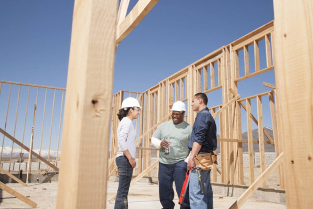 The Most Overlooked Details in Early Home Construction Planning Construction manager reviewing blueprints on home site