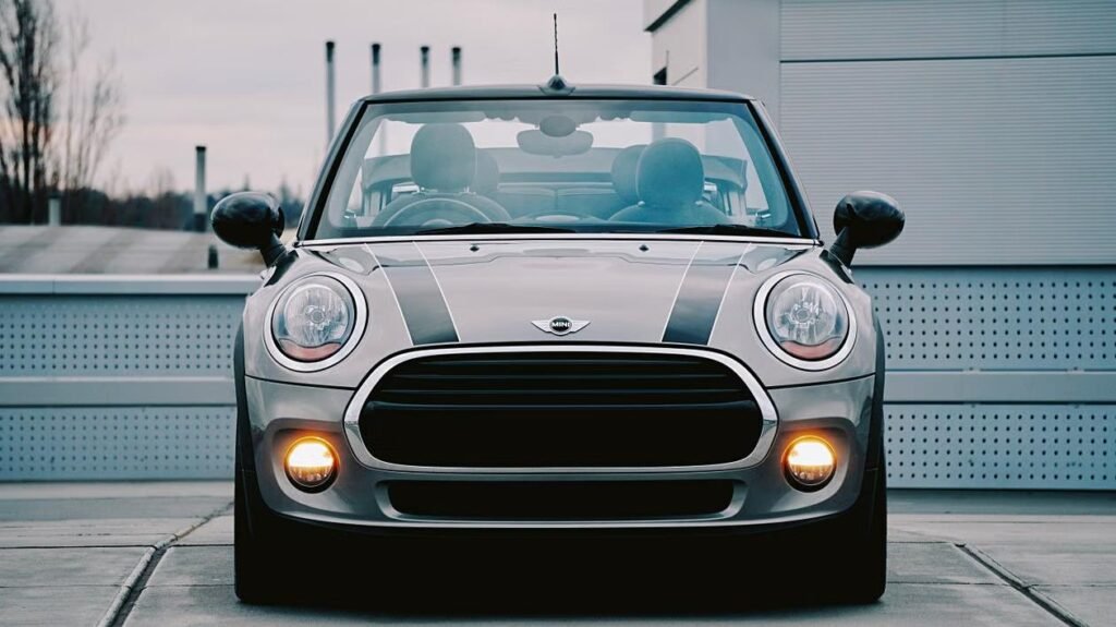 Gray Mini Cooper convertible with fog lights on